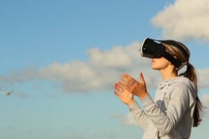 A woman wearing a VR headset gazes upward, immersed in a virtual experience of the sky.