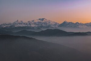 A breathtaking sunrise illuminating the majestic mountains of Nepal, casting warm hues across the serene landscape.