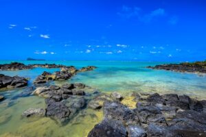 A scenic view of the ocean and rocky formations along the shore of Kauai, Hawaii, showcasing natural beauty and tranquility.