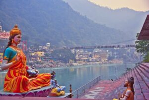 A statue of a woman seated on a ledge, gazing thoughtfully at the flowing river below.